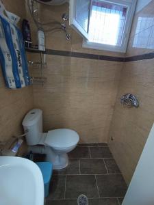 a bathroom with a toilet and a sink and a window at Blue Dolphins 2 bedroomed house with court yard in Skiathos Town +14 photos