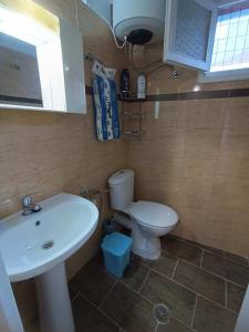 a bathroom with a white sink and a toilet at Blue Dolphins 2 bedroomed house with court yard in Skiathos Town