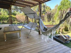 - un hamac sur une terrasse avec une table et un banc dans l'établissement Punta colorada, casa con jacuzzi dos baños, à Punta Colorada
