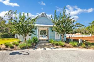 una casa blu con degli alberi di fronte di Casita Grayton a Santa Rosa Beach