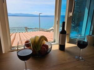 a basket of fruit and two glasses of wine on a table at Studio Sea view in Bol