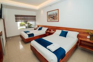 a bedroom with two beds and a window at Hotel Ninfa in Puerto Ayora +26 photos