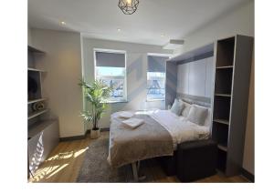 ein Schlafzimmer mit einem Bett und einer Topfpflanze in der Unterkunft Bright Finchley Apartments - Perfect for Business & Leisure in Finchley