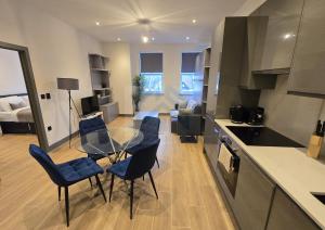 eine Küche und ein Wohnzimmer mit einem Glastisch und Stühlen in der Unterkunft Bright Finchley Apartments - Perfect for Business & Leisure in Finchley