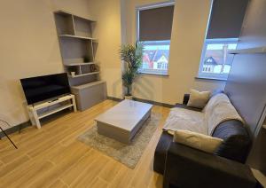 ein Wohnzimmer mit Sofa und Fernseher in der Unterkunft Bright Finchley Apartments - Perfect for Business & Leisure in Finchley