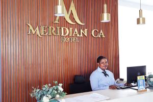 ダル・エス・サラームにあるMeridian CA Hotelの机の上に座る女