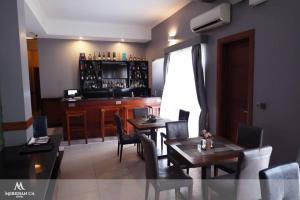a dining room with a table and chairs and a bar at Meridian CA Hotel in Dar es Salaam