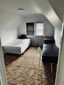 a bedroom with a bed and a desk and a window at Rooms available downtown Winnipeg in Winnipeg