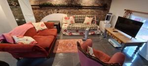a living room with a couch and a tv at lavender house in Ironbridge