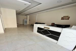 a man sitting on a couch in a living room at Super OYO 146 Jandul Salalah Furnished Apartment in Salalah