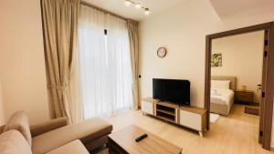 a living room with a couch and a tv and a mirror at OYO 1292 Home Fully Furnished 1bed Apt @JVC in Dubai