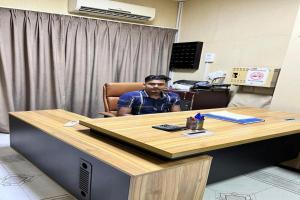 a man sitting at a desk in an office at Super OYO 149 Bait Al Ghubaira Furnished Flat in Salalah