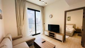 a living room with a couch and a television at OYO 1291 Home Fully Furnished 1bed Apt @JVC in Dubai