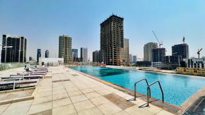 una piscina in cima a un edificio con una città di OYO HOME 1364 Fully Furnished Studio Apartments Jvc a Dubai