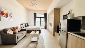 un piccolo soggiorno con divano e frigorifero di OYO HOME 1364 Fully Furnished Studio Apartments Jvc a Dubai