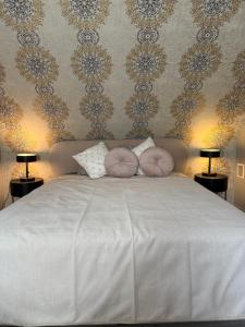 a bedroom with a white bed with two pillows at Domek w lesie nad zalewem in Chańcza
