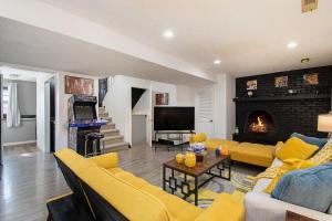 a living room with yellow furniture and a fireplace at Charming Elegance Getaway in Omaha