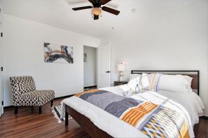 a bedroom with a bed and a ceiling fan and a chair at Charming Elegance Getaway in Omaha