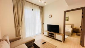 a living room with a television and a mirror at OYO 1287 Home Fully Furnished 1Bed At JVC in Dubai