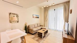 a living room with a couch and a table at OYO 1287 Home Fully Furnished 1Bed At JVC in Dubai