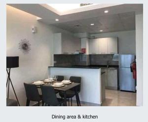 Essbereich und Küche mit Tisch und Stühlen in der Unterkunft OYO HOME 1387 Premium 1bedroom Apartment in Dubai + 2 Fotos