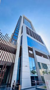 deux personnes assises devant un grand bâtiment dans l'établissement Upscale Studio Apartment Business Bay with Balcony and Free Parking by BelVilla, à Dubaï