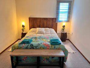 a bedroom with a large bed with a wooden headboard at Depto CENTRICO AURA in Río Gallegos