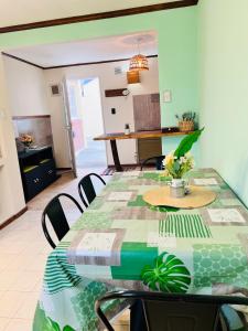 a dining room with a green table and chairs at Depto CENTRICO AURA in Río Gallegos +20 photos