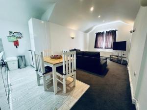 a living room with a table and a couch at Stylish 1 Bedroom Flat in the Heart of Staines in Staines upon Thames