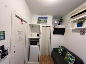 une petite pièce avec un canapé et un micro-ondes dans l'établissement Casa Sur H1, à Cordoue