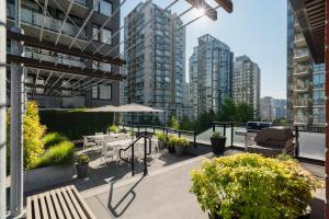 an outdoor patio with tables and chairs and buildings at Level Vancouver Yaletown Seymour in Vancouver