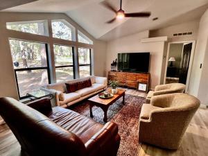 a living room with leather couches and a tv at The Pine Tree Palace in Bastrop