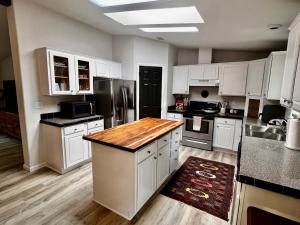 a kitchen with white cabinets and a wooden counter top at The Pine Tree Palace in Bastrop