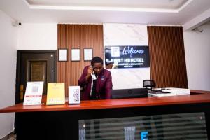 a man talking on a cell phone at a desk at First HR Hotel in Prampram +87 photos