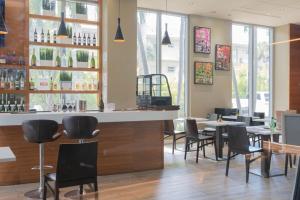 ハランデール・ビーチにある2B 2B Beachfront Pool Gym, and Restaurantのテーブルと椅子のあるレストラン内のバー