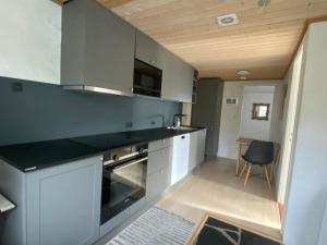 a kitchen with white cabinets and a black counter top at Cosy apartment in Kvívík