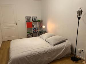 a bedroom with a white bed and a lamp at Le Central Victoria VII - Central district - Stanislas - Train station in Nancy