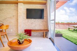 a living room with a tv on a brick wall at Qavi - Flat Vista Mar de Pirangi #Living14 in Pirangi do Norte