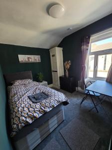 a bedroom with a bed and a blue wall at Kings Road Modern Home in Middlesbrough