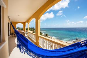 a balcony with a hammock overlooking the ocean at The Strand - The Beach, Penthouse 4A in Willemstad