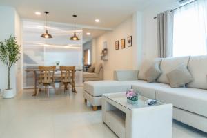 a living room with a couch and a table at Sunny's Cozy Home in Bophut