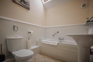 un bagno con un water, una vasca e un lavandino di Humble Bee Cottage a Folkton