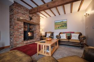 un soggiorno con divani e camino di Humble Bee Cottage a Folkton