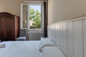 a bedroom with a large bed with a window at DUE TORRI 1 LUXURY PALACE- BEDINBOLOGNAcentro in Bologna