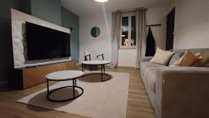 een woonkamer met een bank en een flatscreen-tv bij Mona Lisa in Sallaumines