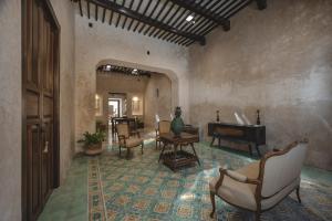 a living room with chairs and a television in a room at La Casa Verde in Campeche +24 photos