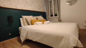 een slaapkamer met een groot wit bed met gele kussens bij Mona Lisa in Sallaumines