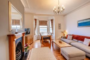 a living room with a couch and a fireplace at St Kitts Apartment in Filey +3 photos