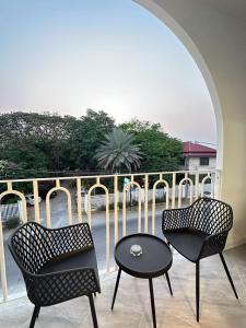 Dos sillas y una mesa en un balcón. en Eli-an Haus, en Phra Nakhon Si Ayutthaya