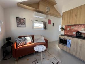 Una sala de estar con un sofá y una cocina. en Casa Saint-Bris, en Villenave-dʼOrnon